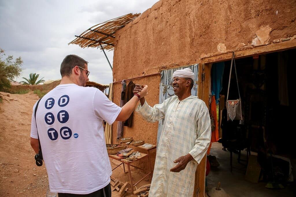 Moroccan local greeting a tourist with a warm smile, showcasing traditional Moroccan hospitality.